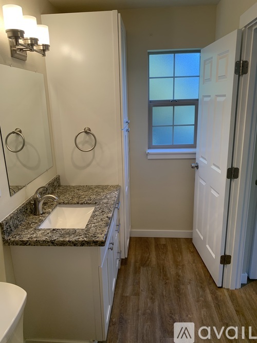 A bathroom with a granite countertop and a window.