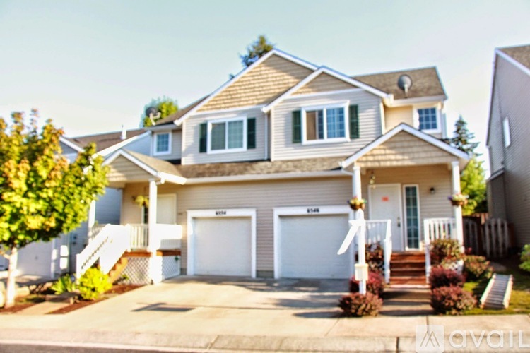 A two-story house with a garage and a driveway.