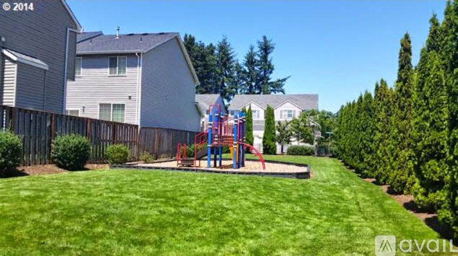A backyard with a playground and a fence.