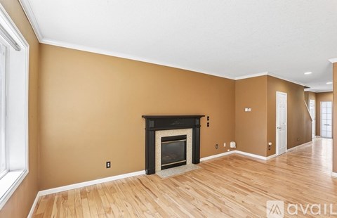 A living room with a fireplace and wooden floors.