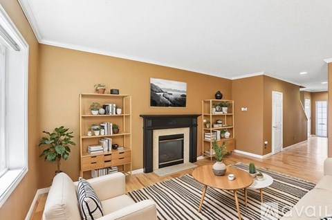 A living room with a fireplace and a painting on the wall.