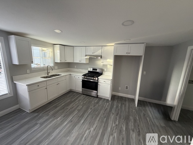 A modern kitchen with white cabinets and stainless steel appliances.