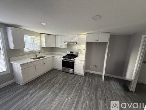 A modern kitchen with white cabinets and stainless steel appliances.
