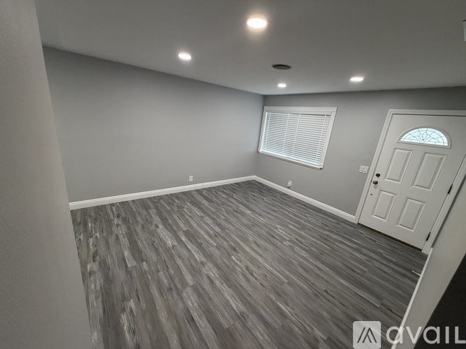 A room with a wooden floor and a white door.