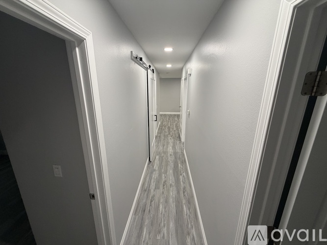 A long hallway with a carpeted floor and white walls.