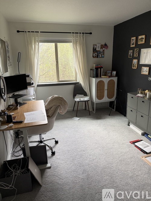 A room with a desk, chair, and computer setup.