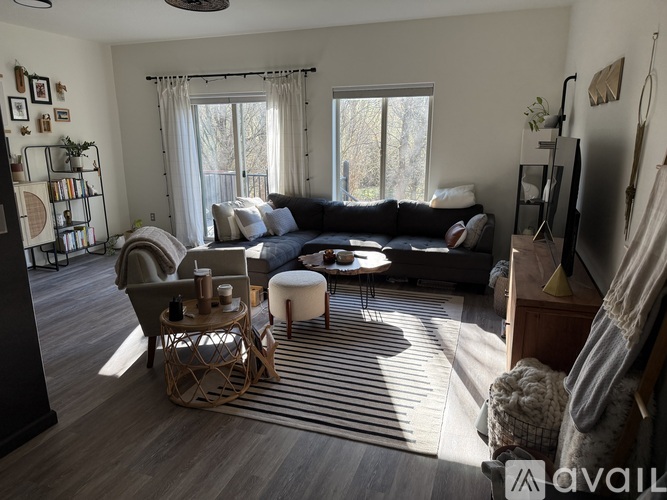 A living room with a large sectional sofa, a chair, a small table, and a rug.