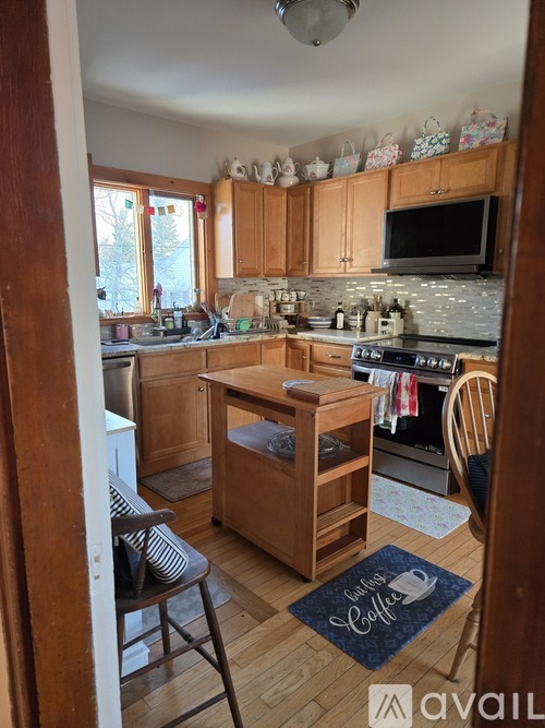 A kitchen with wooden cabinets and a blue mat on the floor.