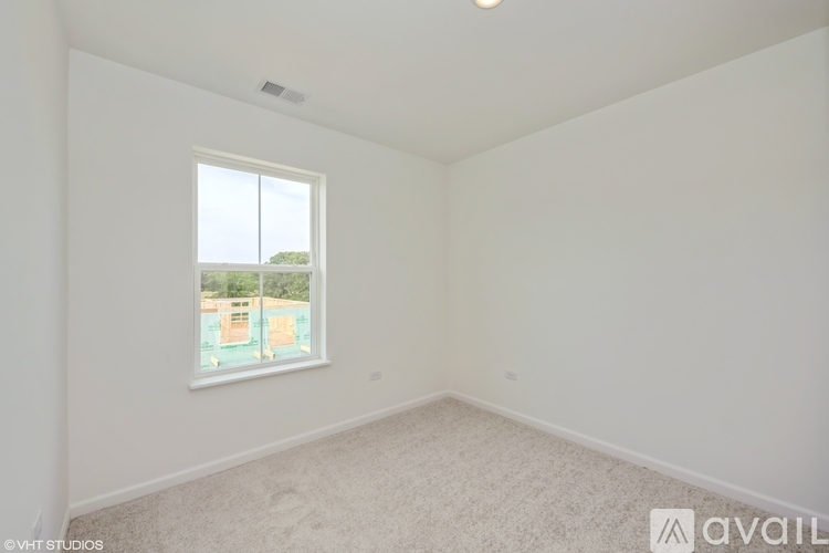 A room with a window overlooking a pool and a view of a building.