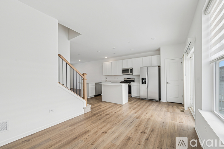 A spacious kitchen with white cabinets and a wooden floor.