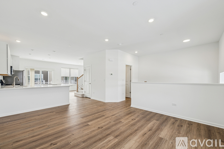 A spacious room with wooden flooring and white walls.