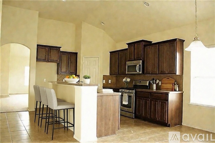 A kitchen with a white island and wooden cabinets.