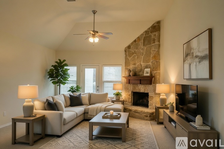 A living room with a stone fireplace and a large couch.
