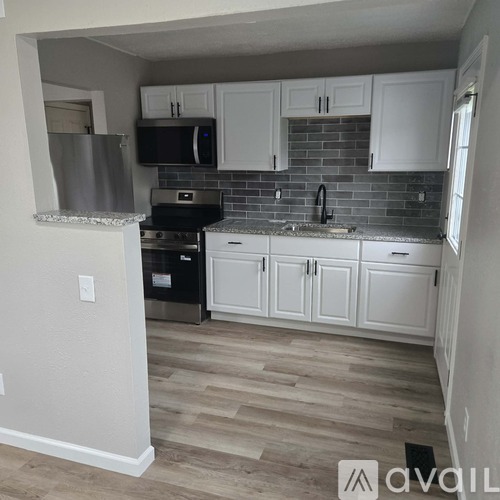 A kitchen with white cabinets and a black stove top oven.