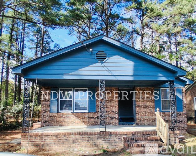 A blue house with the sign NDW PROPERTIES in front of it.