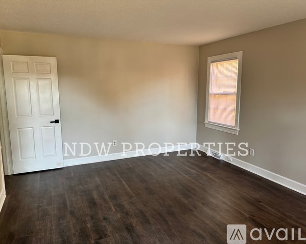 A room with a white door and a window with blinds.