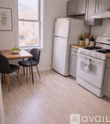 A kitchen with a white fridge and stove, a table with two chairs, and a window.