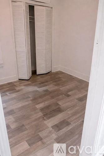 A room with wooden flooring and a white door.