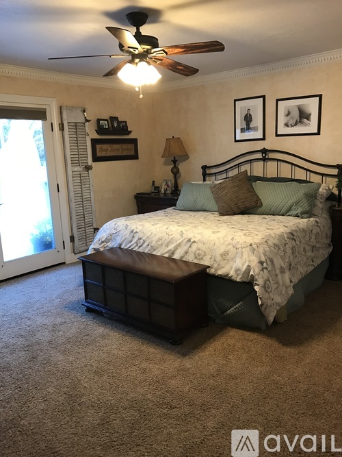 A bedroom with a bed, nightstand, and lamp.
