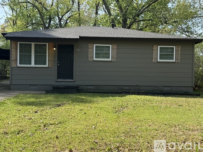 A small house with a black door and two windows.