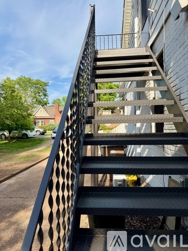 A black metal staircase with a diamond pattern on the railing.