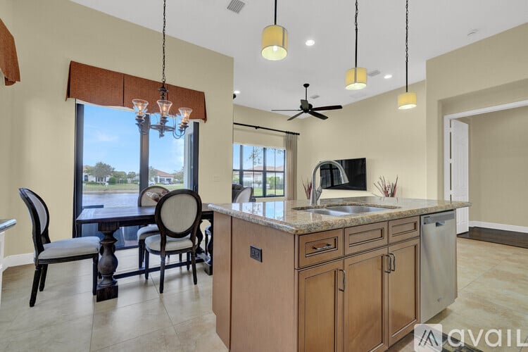 A kitchen with a wooden island and a dining table with chairs.