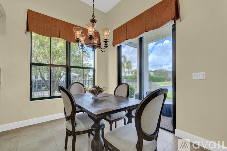 A dining room with a table and chairs and a chandelier.