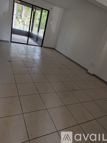 A room with tiled flooring and a sliding glass door.