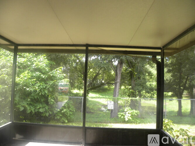 A view from inside a building looking out to a green, leafy area.