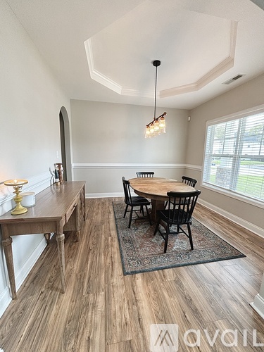 A dining room with a wooden table and chairs.
