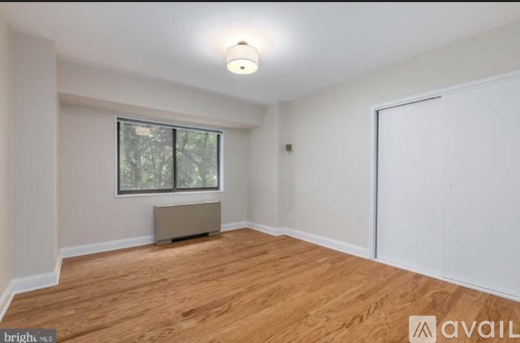 A room with a window and a wooden floor.