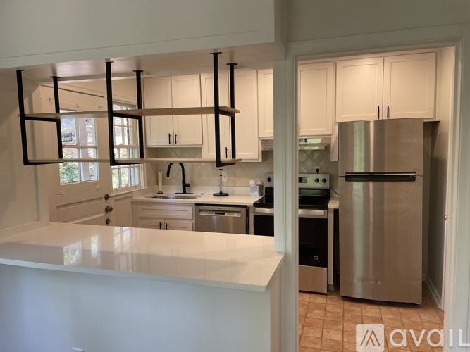 A kitchen with a white countertop and stainless steel appliances.