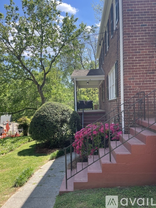 A brick building with a porch and steps leading up to it.