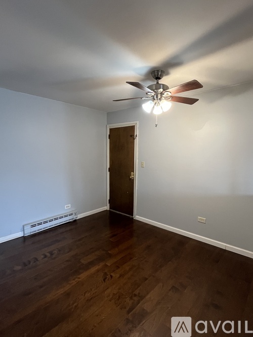 A room with a ceiling fan and a door.