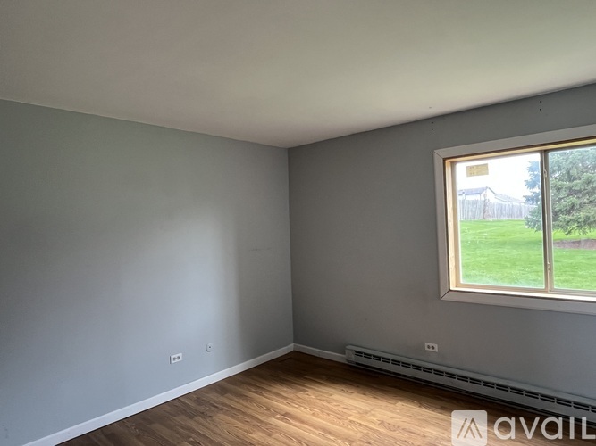 A room with a window and wooden flooring is available for rent.