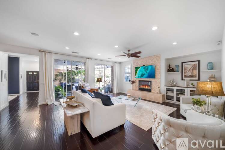 A spacious living room with a fireplace and a painting on the wall.