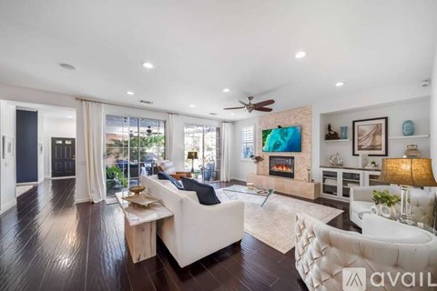 A spacious living room with a fireplace and a painting on the wall.