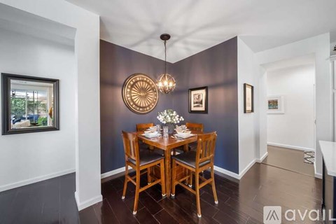 A dining room with a wooden table set for two.