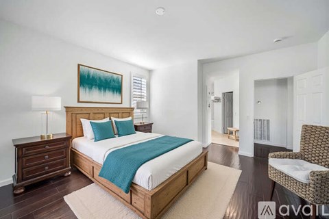 A bedroom with a large bed and a chair.