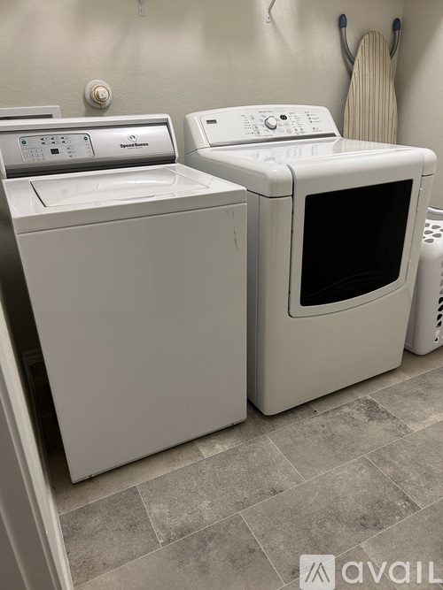 A white dryer and washing machine in a laundry room.