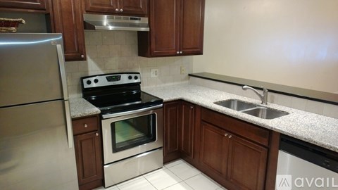 A kitchen with a stove, sink, and refrigerator.