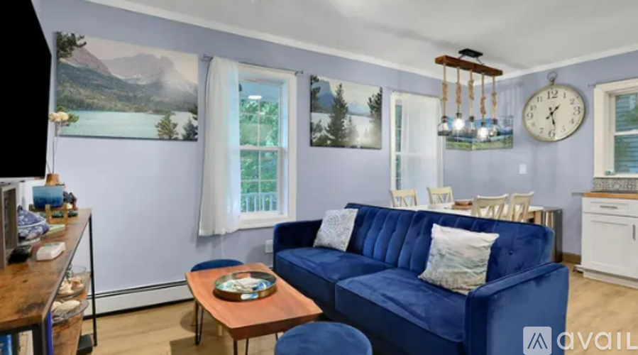 A living room with a blue couch and a wooden coffee table.