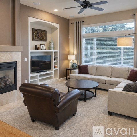 A living room with a brown leather chair and a white couch.