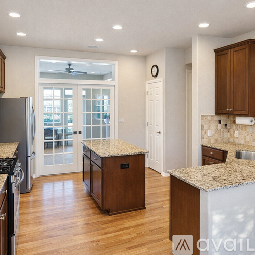 A kitchen with granite countertops and wooden cabinets.