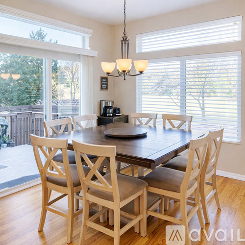 A dining room with a wooden table and chairs.