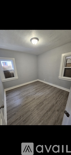 A room with a window and a wooden floor.