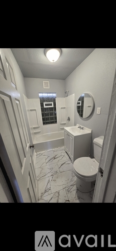 A bathroom with a toilet, sink, and mirror.