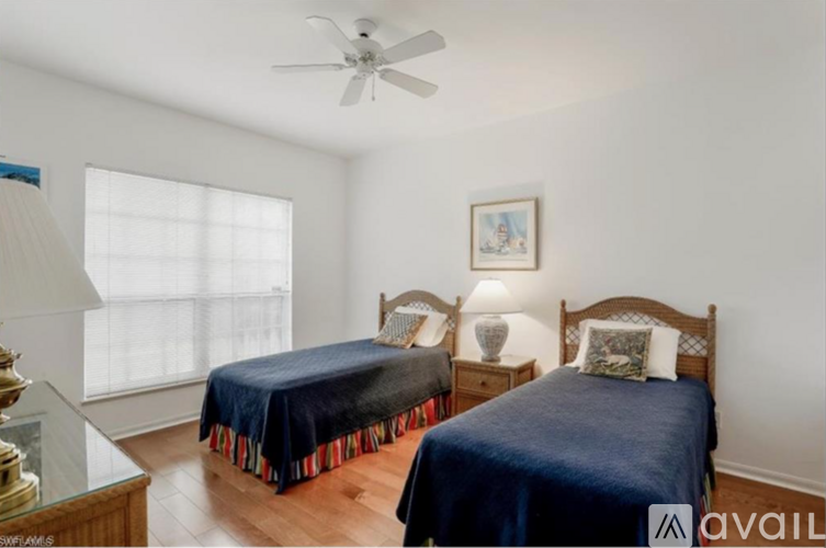 A bedroom with two beds and a ceiling fan.