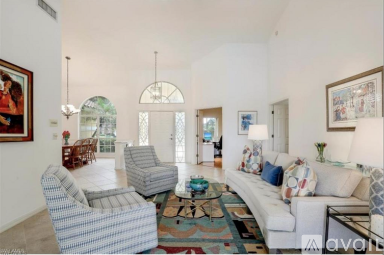 A living room with a pool outside the window.