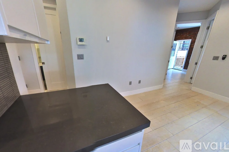 A kitchen with a black countertop and white cabinets.
